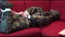 Jill tied, gagged and hooded on a red sofa wearing sexy shiny nylon camouflage rainwear (Video)