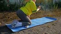 Anastasia is doing some fitness and stretching while smoking outdoors