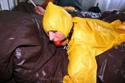 Stella tied and gagged in a shiny yellow rainsuit