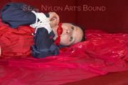 Lucy tied, gagged and hooded with ropes on a sofa wearing a sexy blue/red rainwear combination (Pics)
