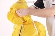 Jill tied and gagged in a shiny yellow rainsuit and rubber boots