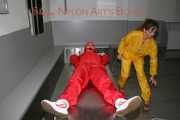 Watching Stella being tied and gagged with ropes and a ballgag on a operating table from Leonie both wearing sexy shiny nylon rainwear (Pics)