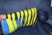 Katharina taped and gagged in a blue nylon rainsuit