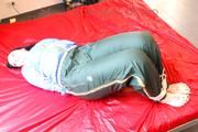 Jill tied and gagged on bed wearing a shiny black pants and a shiny blue rain jacket (Pics)