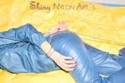 Alina wearing a sexy shiny rainwear suit in blue lolling on bed cuffed (Pics)