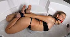 Ballgagged barefoot Albina Rose in bikini, hogtied with her hands separately tied to her ankles, wiggles in jacuzzi