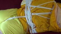 Lucy tied and gagged on a red sofa wearing a sexy yellow shiny nylon shorts and a yellow rain jacket (Video)
