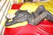 Lucy preparing her bed and enjoys it wearing sexy black rainwear (Pics)