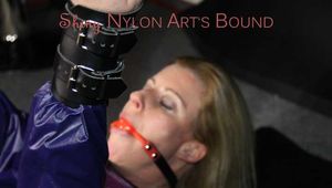 Watching sexy Pia wearing a sexy blue oldschool shiny nylon shorts and a rain jacket being tied and gagged on hands and feet on the ceiling lying on the floor (Pics)