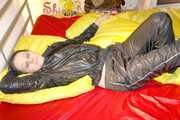 Lucy preparing her bed and enjoys it wearing sexy black rainwear (Pics)