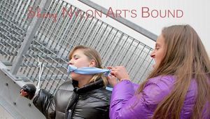 One archive girl tied and gagged by another archive girl outdoor wearing shiny down jackets (Pics)