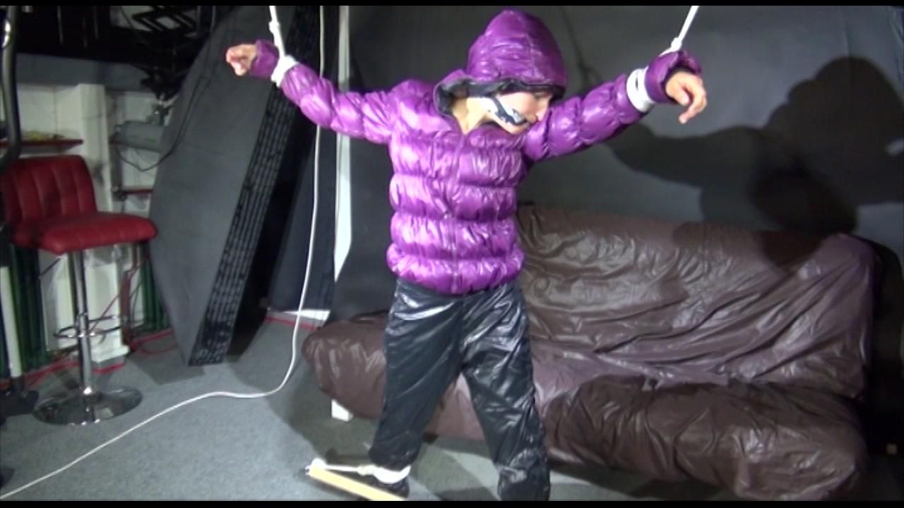 Sexy Sandra Being Tied And Gagged Overhead With Ropes And A Bar Wearing A Sexy Black Rain Pants And A Purple Down Jacket With Hood Closed (Video)