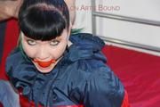 Jill tied and gagged on the bed with cable binders in a black shiny nylon pant and an red/Blue shiny rain jacket (Pics)