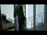 Enni with black shiny nylon shorts and rain pants and a rain jacket over naked skin smoking a cigarette (Video)