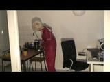 Blonde-haired archive girl being at home wearing shiny nylon rainwear (Video)