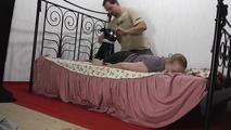 Ginger in hogtie on bed 2/2