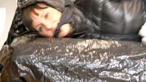 Mara tied, gagged and hooded on a black covered sofa wearing a blue rain pants and a black down jacket (Pics)