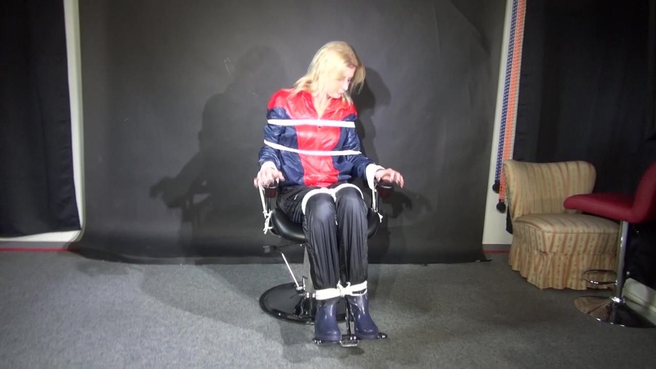 Watzching Sexy Pia Wearing A Sexy Oldschool Rainwear Combination In Red/Blue Sitting On A Hairdresser's Chair Being Tied And Gagged From Sophie (Video)