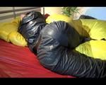 Lucy lolling in bed wearing a sexy black rainwear combination (Video)