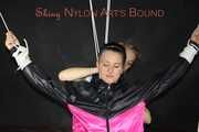 Sexy Mara tied, gagged and hooded overhead on hands and feet with ropes and a cloth gag wearing a sexy black/pink rainwear combination (Pics)
