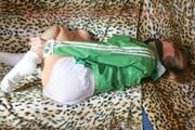 Leonie tied and gagged on a sofa wearing a white shiny nylon shorts and a green rain jacket (Pics)