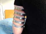 Lea wearing five very tight hose clamps on each arm