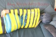 Katharina tied and gagged with tape on a sofa wearing shiny rainwear (Pics)