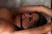 Ballgagged barefoot topless Cynthia in white panties, tied on the bed with her legs pulled up and tied wide-spread, is being played with vibrator by camera man