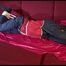 Lucy tied and gagged with ropes and a cloth gag on a sofa wearing a blue/red rainwear combination (Video)
