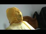 Jill tied and gagged on a chair wearing a yellow rainsuit and coveres with an yellow raincoat with two hoods (Video)
