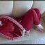 Jill tied, gagged and hooded on a white sofa wearing a sexy shiny red nylon shorts and a red rainjacket (Video)