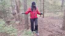 Sebastien breathplay tied up in a puffer jacket among the trees.