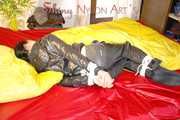 Lucy preparing her bed and enjoys it wearing sexy black rainwear (Pics)