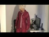 Blonde-haired archive girl being at home wearing shiny nylon rainwear (Video)
