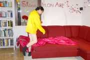 Lucy wearing a sexy red shiny nylon shorts and a yellow rain jacket preparing the sofa to lay down (Pics)
