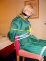 Blonde archive girl tied and gagged in an green shiny nylon rainsuit on a chair (Pics)