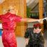 One archive girl tied and gagged by another one on two pillars wearing shiny nylon rainwear (Pics)