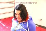 Jill tied and gagged on bed wearing a shiny black pants and a shiny blue rain jacket (Pics)