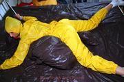 Stella tied and gagged in a shiny yellow rainsuit