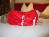Beautiful archive girl tied and gagged on a bed wearing shiny shorts (Pics)