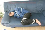Katharina tied, gagged and hooded (breath control) on a sofa wearing sexy shiny nylon rainwear (Pics)