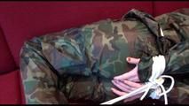 Jill tied, gagged and hooded on a red sofa wearing sexy shiny nylon camouflage rainwear (Video)