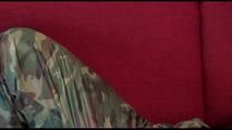 Jill tied, gagged and hooded on a red sofa wearing sexy shiny nylon camouflage rainwear (Video)