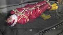 Alice bound and gagged in a nylon Rainsuit