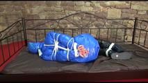 Pia tied, gagged and hooded on a princess bed in an old cellar wearing a sexy shiny down coat, down pants and down boots (Video)
