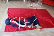 Julia tied and gagged in a shiny nylon skisuit