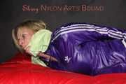 Sexy Pia being tied and gagged with ropes and a clothgag on a bed wearing a sexy darkblue shiny nylon shorts and a sexy blue/purple rain jacket (Pics)
