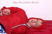 Pia tied and gagged on bed in a shiny bluerainpants and red rainjackert (Pics)