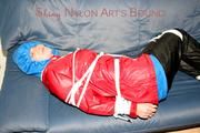 Jill tied, gagged and hooded on the sofa wearing a sexy black shiny nylon pants and two rain jackets (Pics)