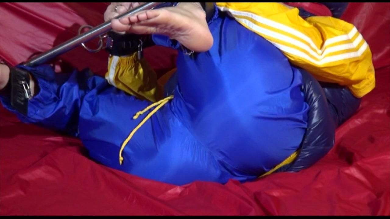 Sonja Ties, Gagges And Hoodes Herself On A Sofa With A Bar And A Ball Gag Wearing A Sexy Blue Shiny Nylon Rain Pants And A Yellow Rain Acket And A Blue Down Jacket (Video)